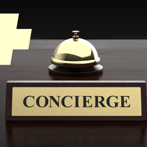A bell on a desk with a sign that says concierge to signal the start of concierge care
